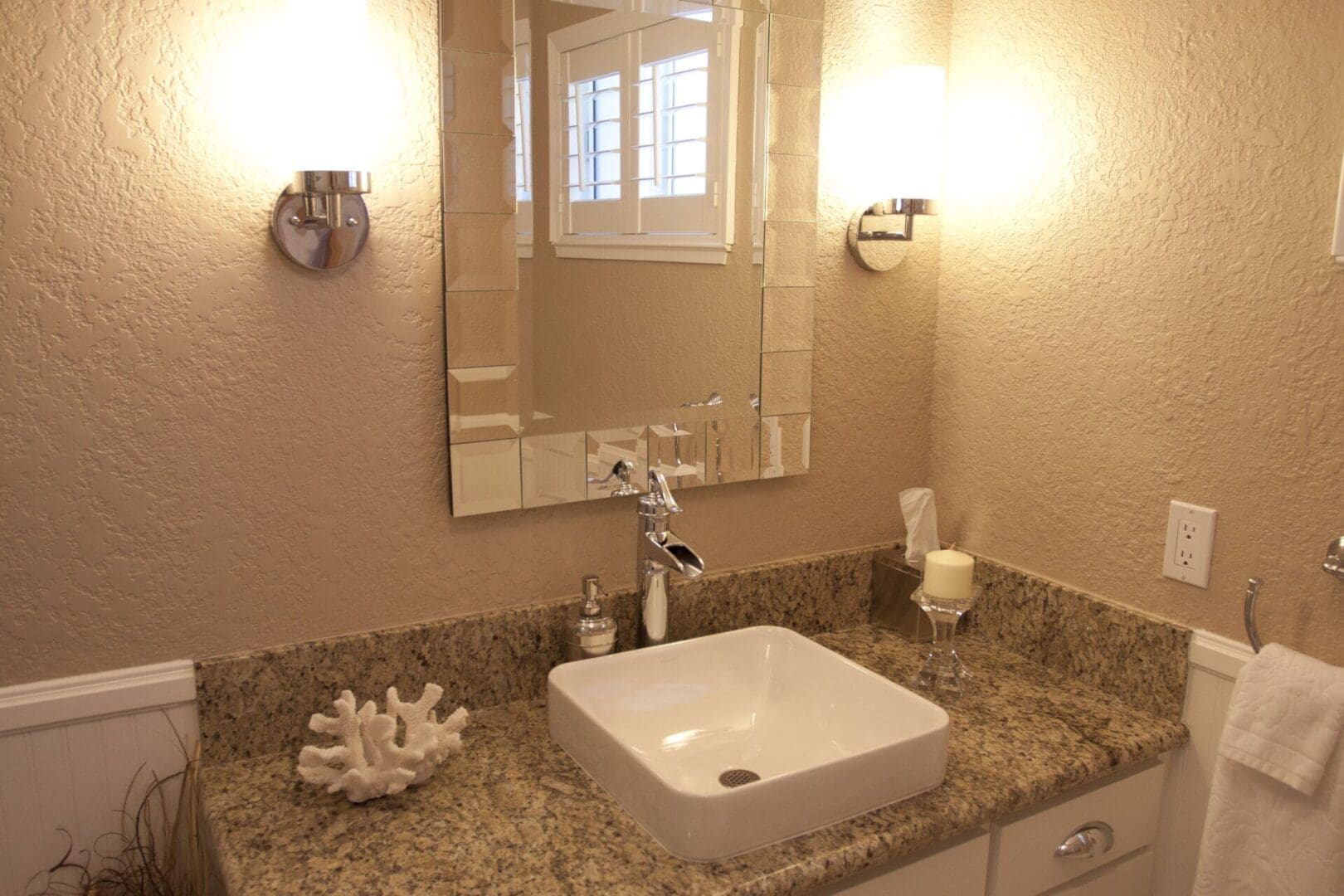 A bathroom with a sink, mirror and window.